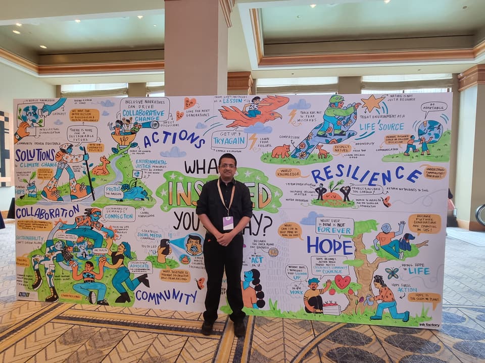 Charith Perera in front of the SRI Congress graphic recording mural